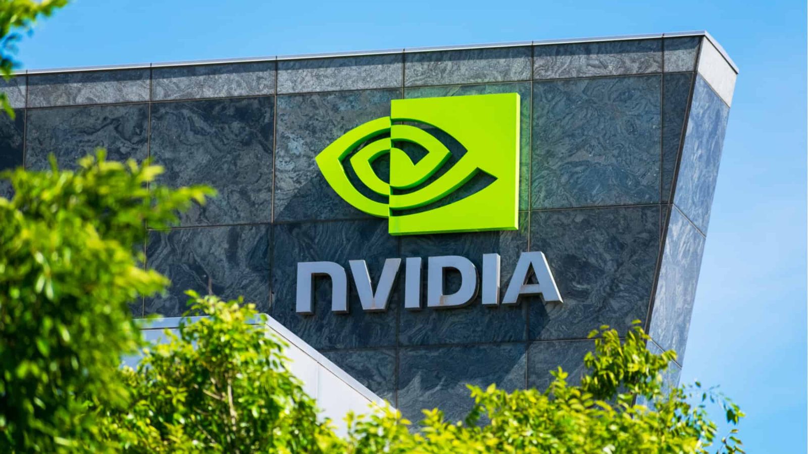 The Nvidia sign on the company’s Santa Clara headquarters, showing the green eye logo above the NVIDIA wordmark on a dark stone facade.