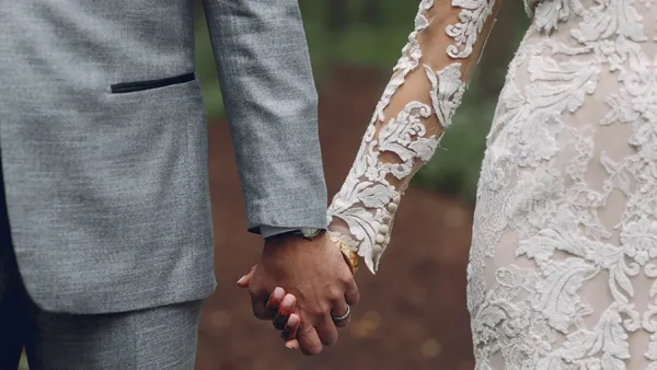 A picture of a married couple holding hands.